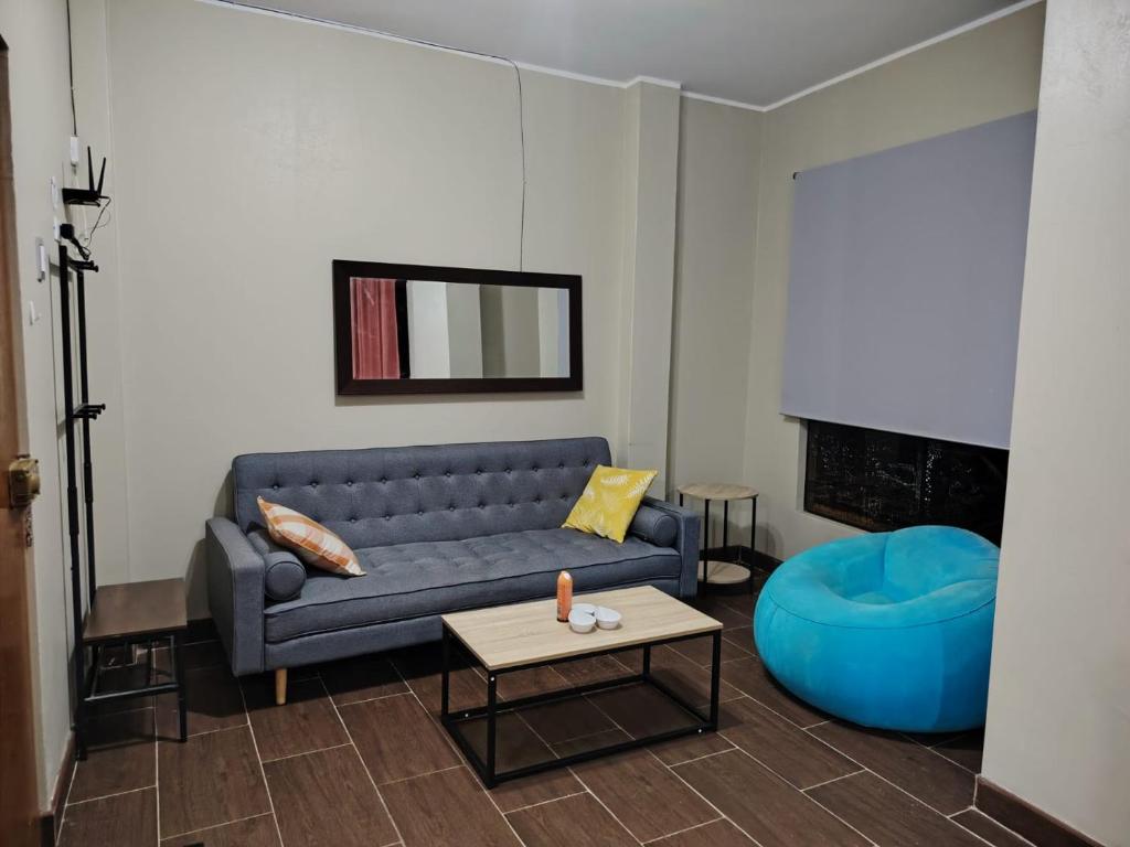 ein Wohnzimmer mit einem blauen Sofa und einem Tisch in der Unterkunft Edificio Las Palmas in Tumbes