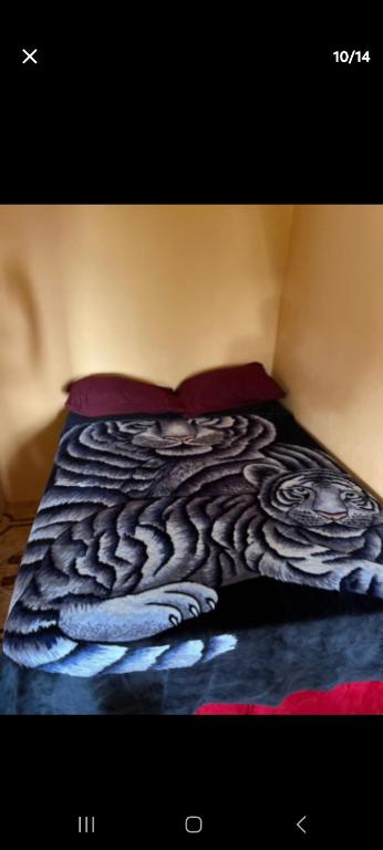 a bed with a snake patterned blanket on it at O-t on the rise in Tweedside