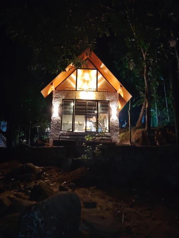 a small house with lights on it at night at komalie resort in Kitulgala