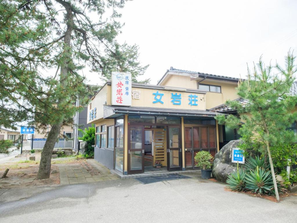 a building with a sign in front of it at Minshuku Meiwaso in Takaoka