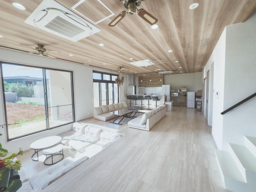 a living room with white couches and a table at guest house ALO in Miyako-jima