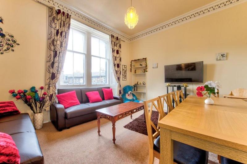 a living room with a couch and a table at Edinburgh Central Drumdryan ApartHotel in Edinburgh