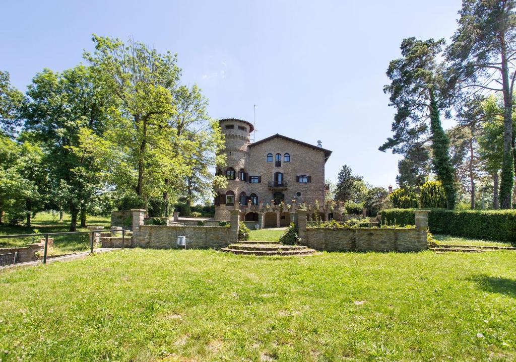 an old mansion with a grassy field in front of it at Alberg Santa Maria del Roure in Cantonigros