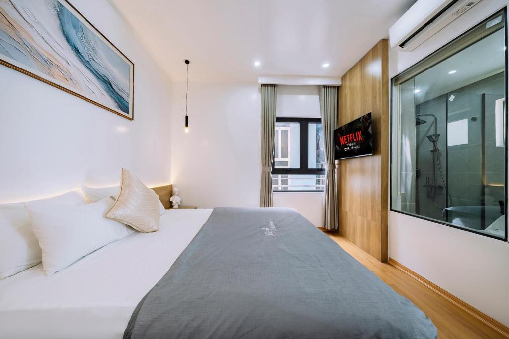 a bedroom with a large white bed and a window at Minn Cat Ba in Cat Ba