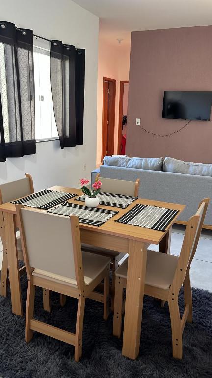 a dining room table and chairs in a living room at Doce Lar 3 in Pouso Alegre