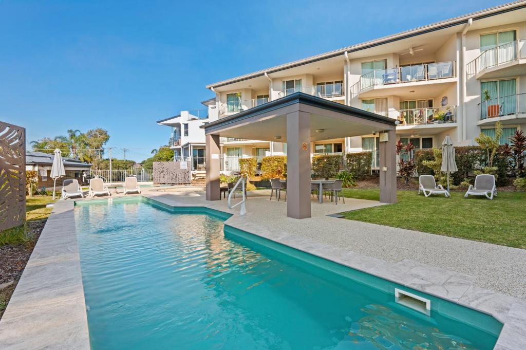 a swimming pool in front of a building at Moana Condo | Close to Beach in Caloundra