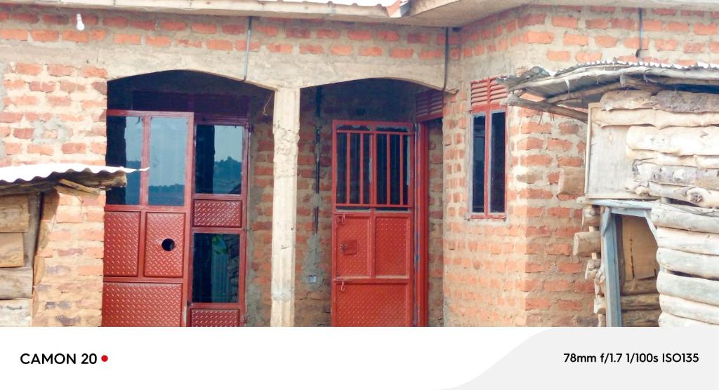 a brick building with red doors on it at Ebenezer Community Development Center in Rubanda