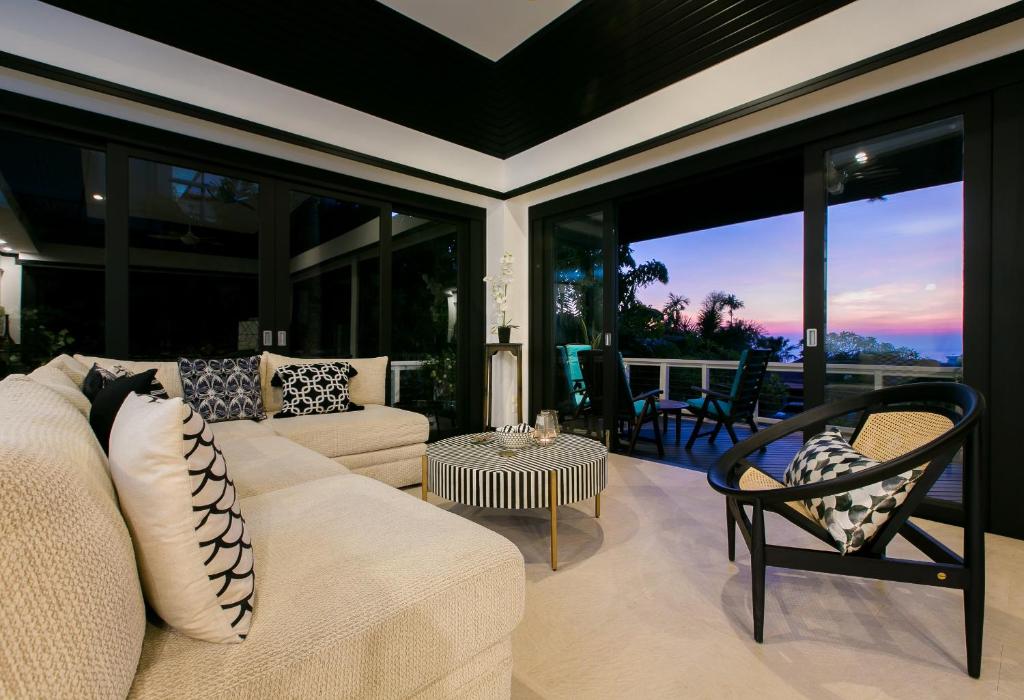 a living room with a white couch and glass windows at Katamanda Villa Jade A6 Seaview Kata Beach in Kata Beach