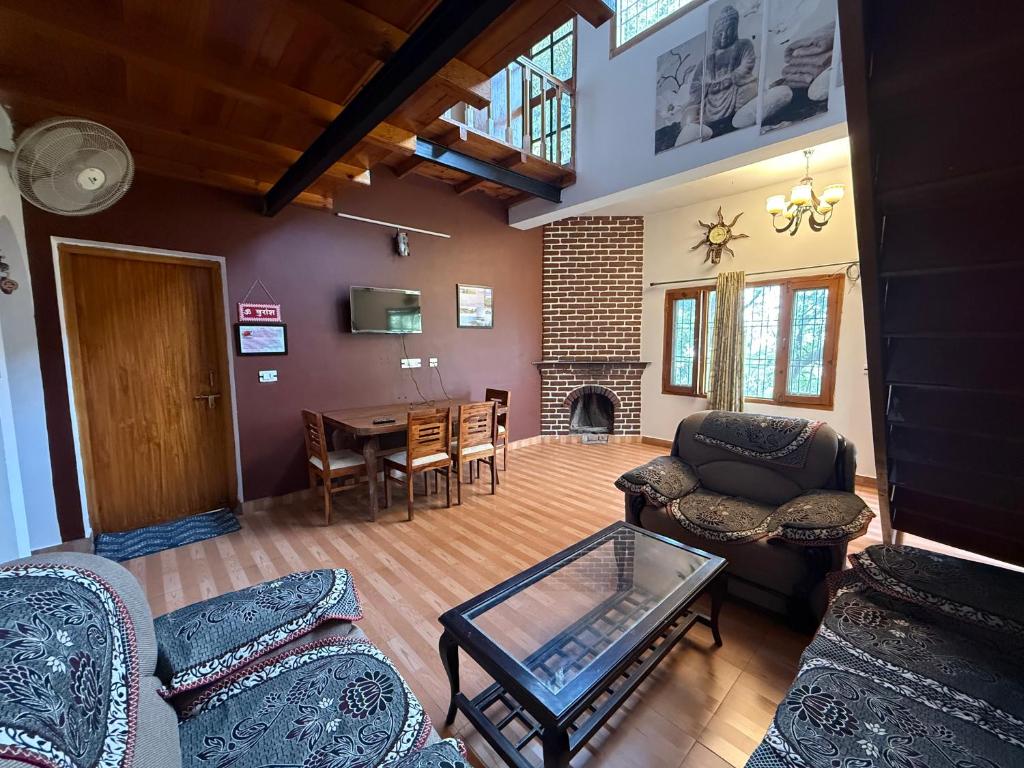 a living room filled with furniture and a table at LRX Retreats in Chaubattia