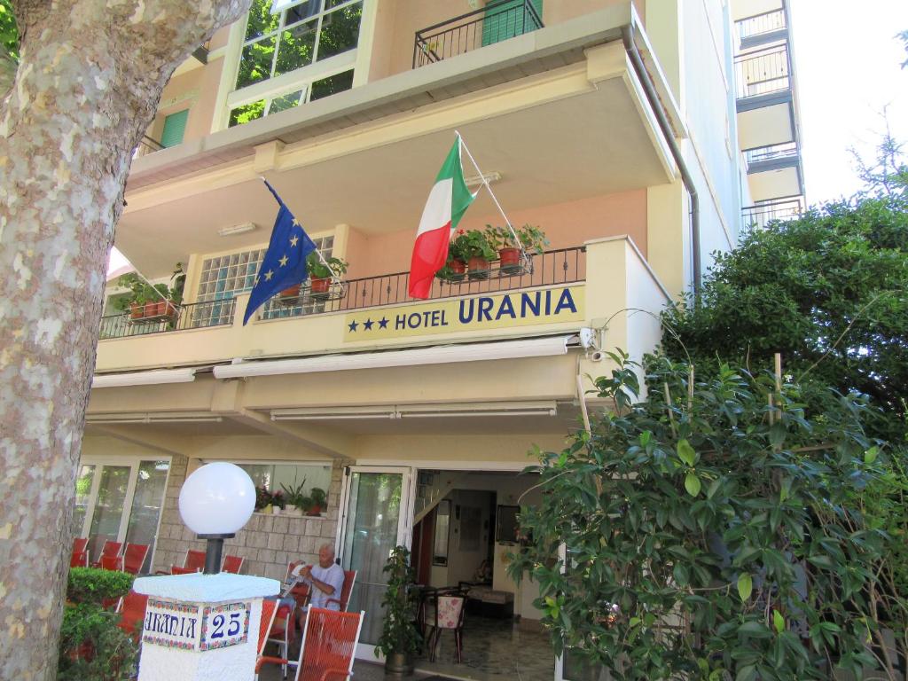 リミニにあるHotel Uraniaの建物の横に二旗のホテル