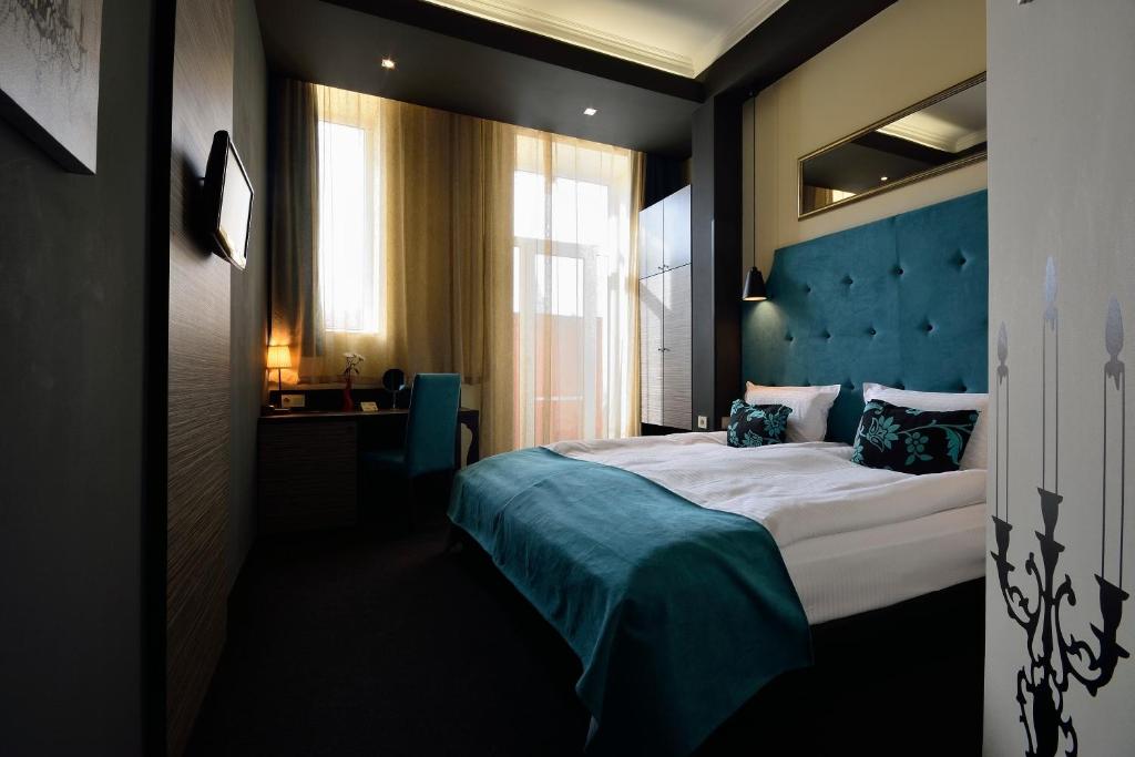 a bedroom with a large bed with a blue headboard at City Art Boutique Hotel in Ruse