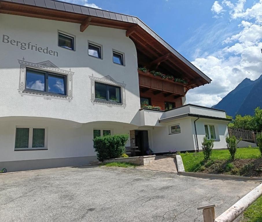 a large white house with mountains in the background at Haus Bergfrieden in Kaunertal