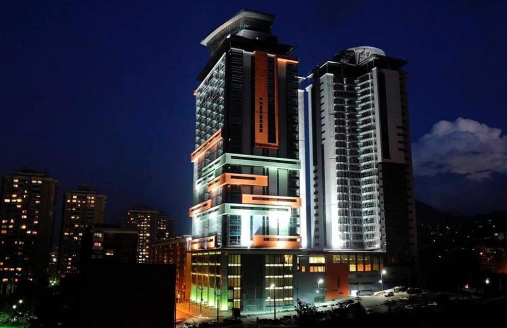 a tall building with lights on in a city at night at Apartmani delux in Sarajevo