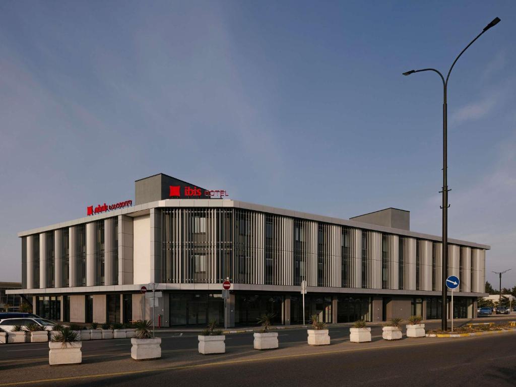 a large building with a sign on top of it at ibis Tbilisi Airport in Tbilisi City