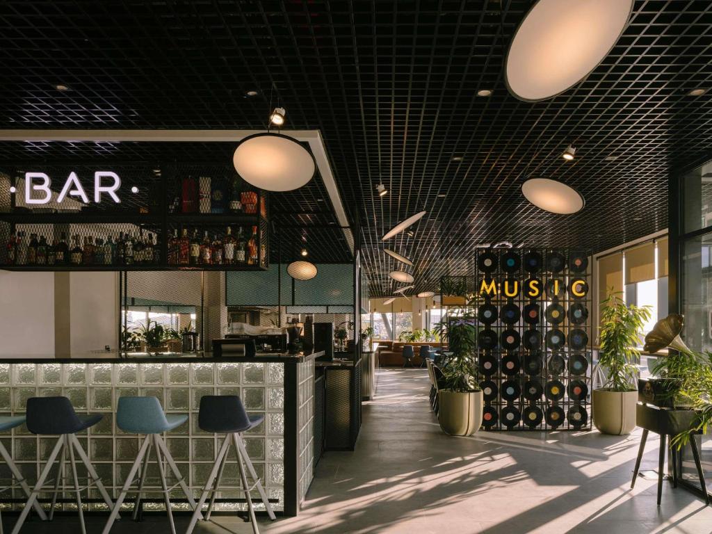 a restaurant with a bar and some bottles of wine at ibis Tbilisi Airport in Tbilisi City
