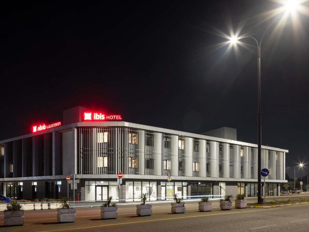 a large white building with lights on top of it at ibis Tbilisi Airport in Tbilisi City