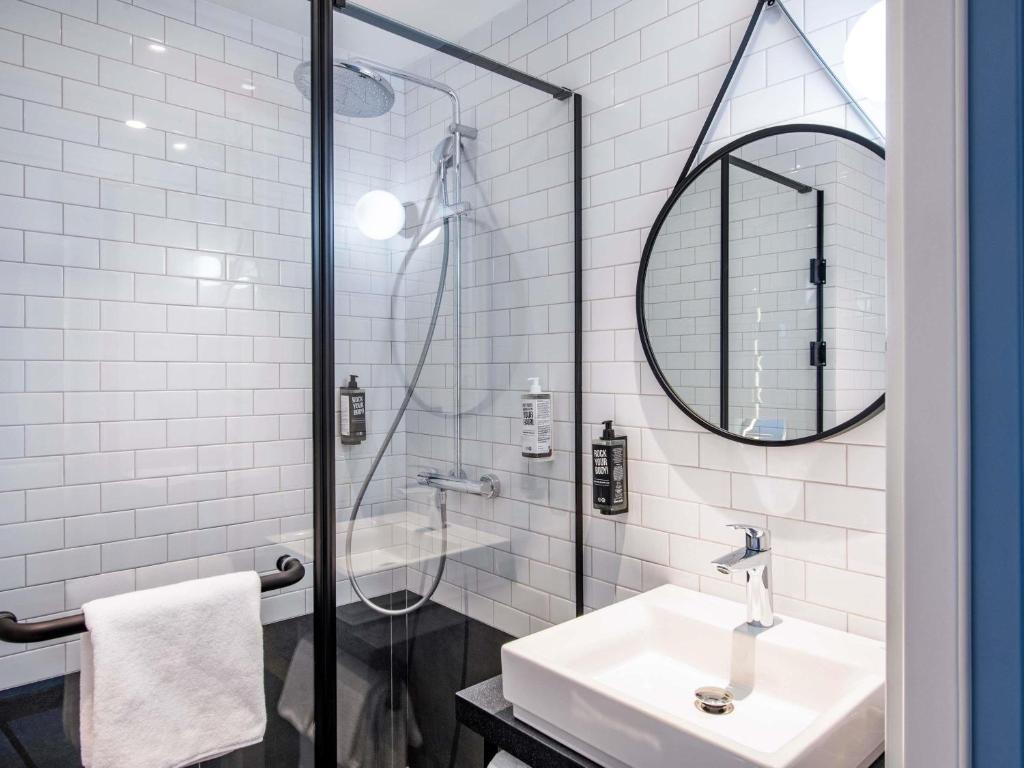 a white bathroom with a sink and a mirror at ibis Tbilisi Airport in Tbilisi City