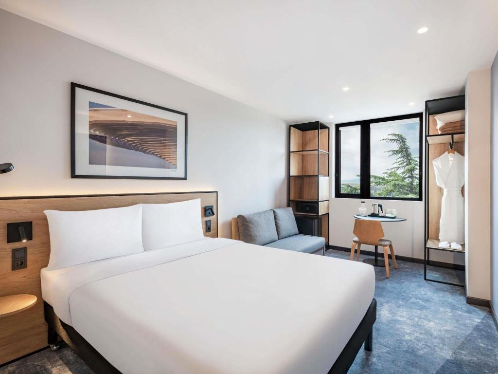 a hotel room with a bed and a chair at ibis Tbilisi Airport in Tbilisi City