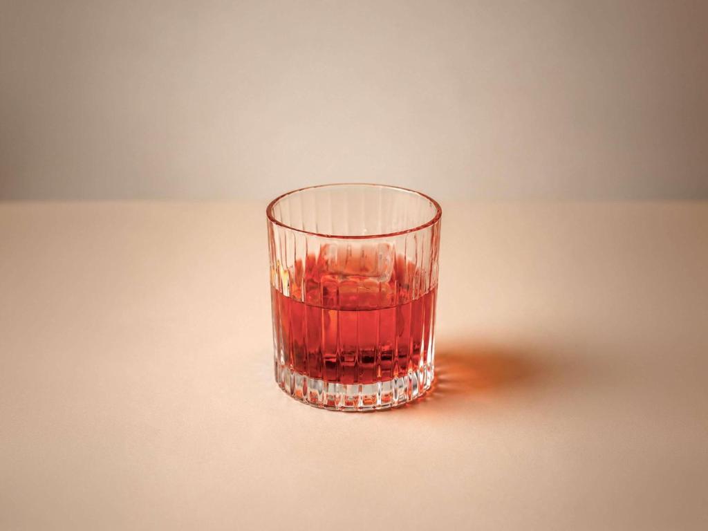 a glass of red liquid sitting on a table at ibis Tbilisi Airport in Tbilisi City