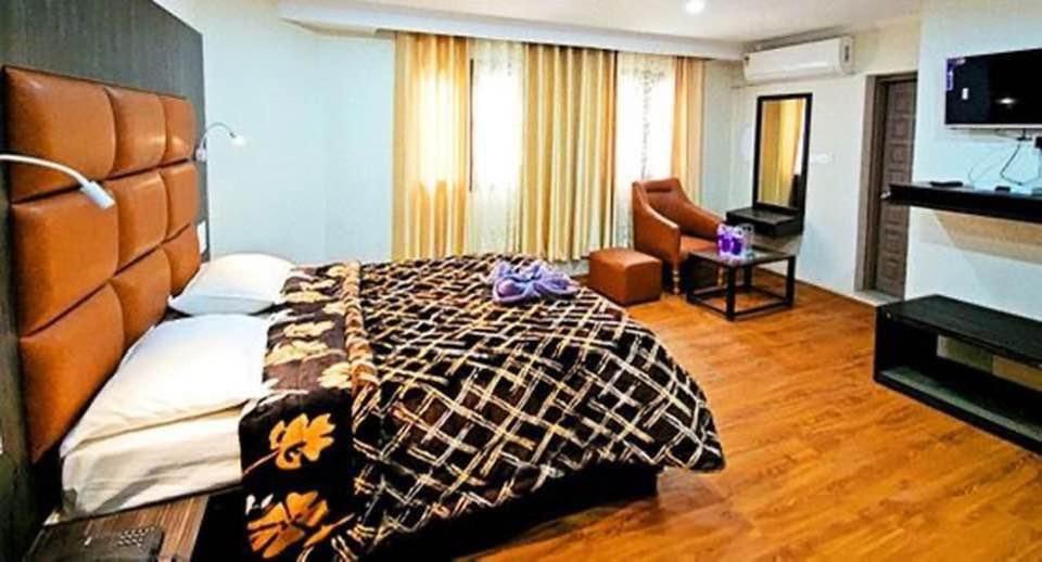 a hotel room with a bed and a television at MGallery in Srinagar