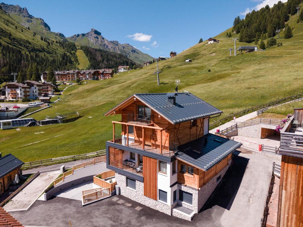 a house with a metal roof on top of a hill at AlpeLuce Mountain Chalet in Arabba