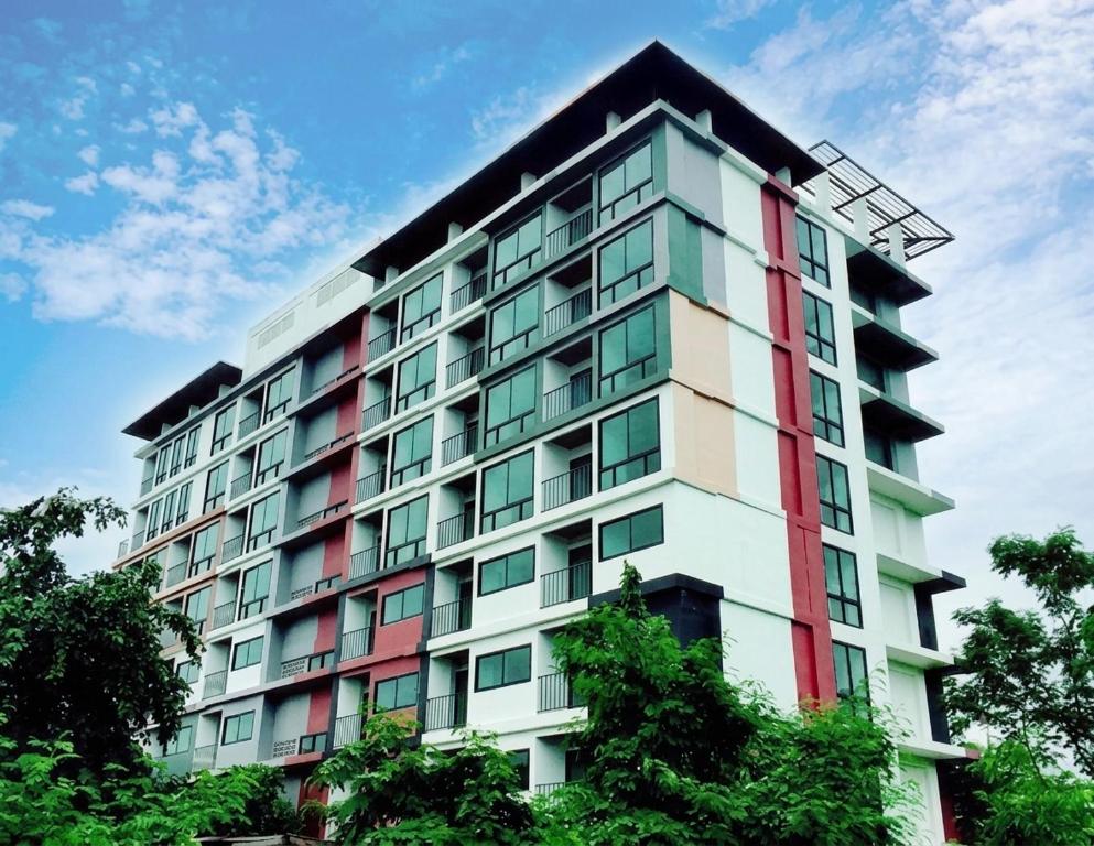 a tall white building with red and green windows at DM udon in Udon Thani