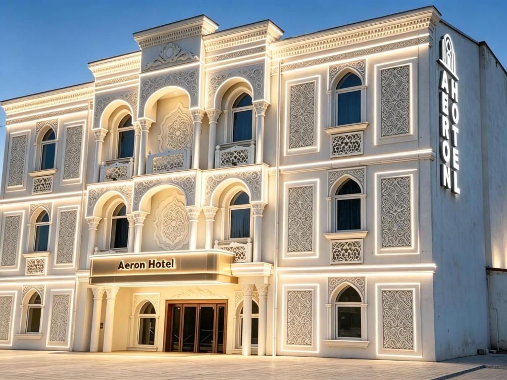 a large white building with a sign on it at AERON hotel in Yakkasaray