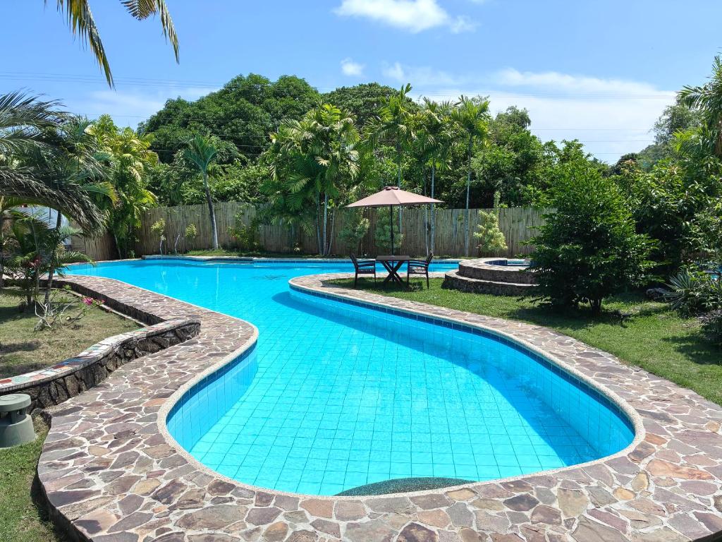a swimming pool with a stone walkway around it at Villa Formosa Panglao in Panglao Island