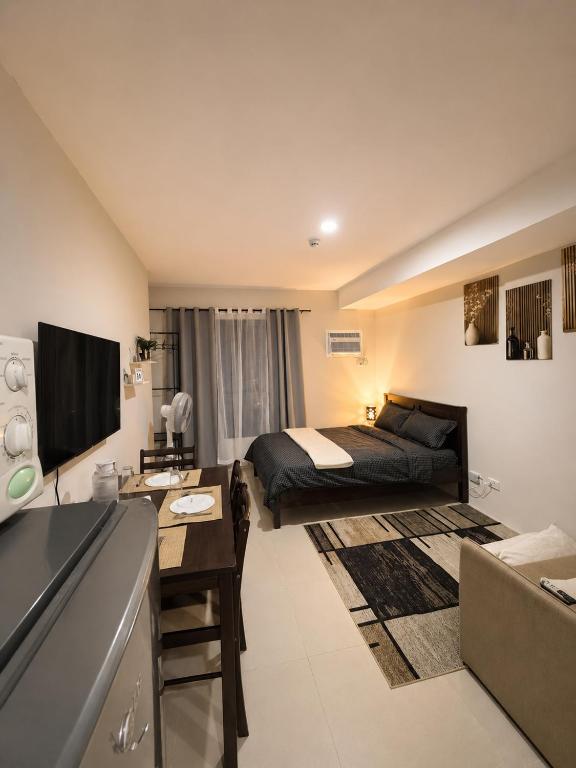 a bedroom with a bed and a desk in a room at Jtower residences mandaue 27flr in Mandaue City