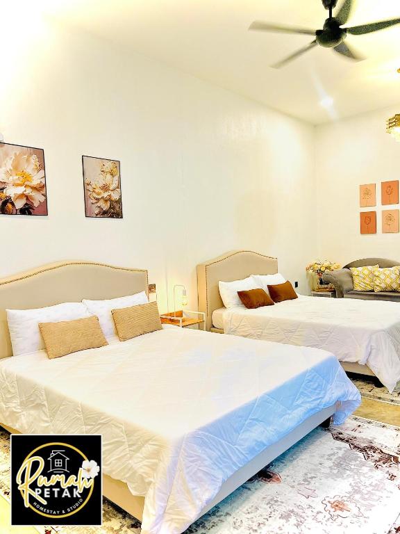 a bedroom with two beds and a ceiling fan at Rumah Petak Melor Muji Concept in Melur