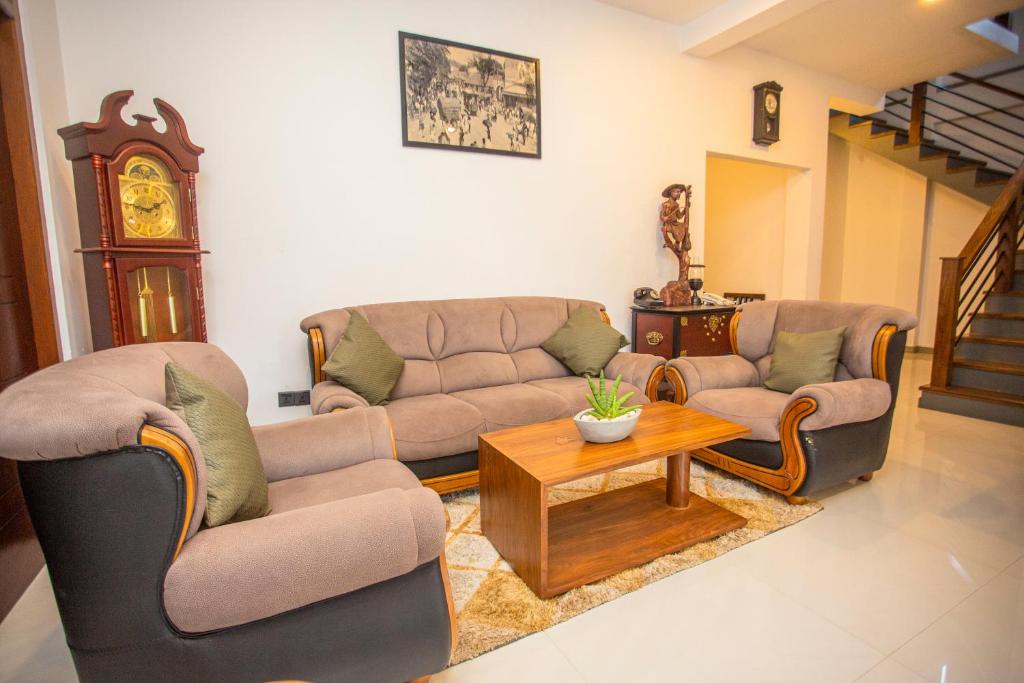 a living room with two couches and a coffee table at Wenzel Villa in Hikkaduwa