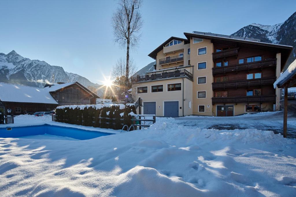 einen schneebedeckten Hof mit einem Gebäude im Hintergrund in der Unterkunft Gasthof Hotel Post in Sautens