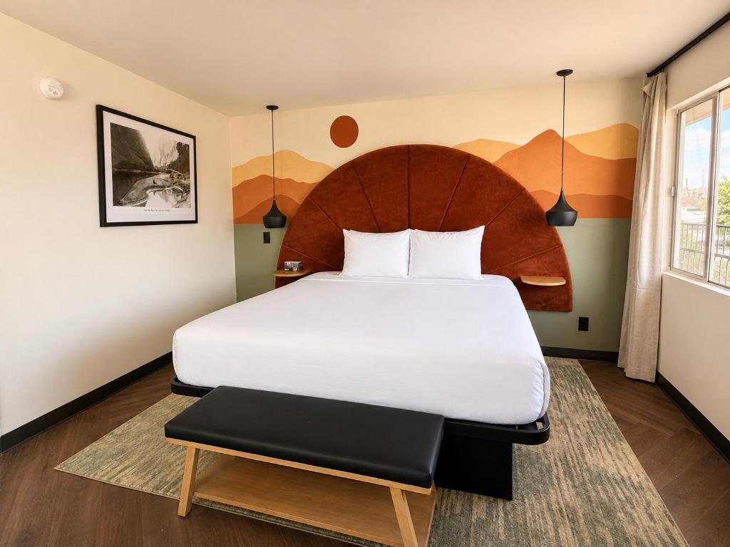a bedroom with a large white bed with a wooden headboard at The Wesley Boutique Hotel Page, AZ in Page