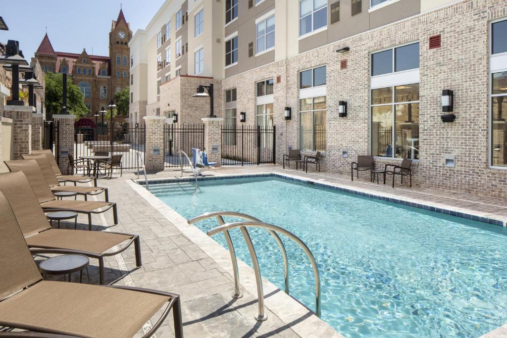 a swimming pool with tables and chairs next to a building at Hyatt Place Sumter/Downtown in Sumter
