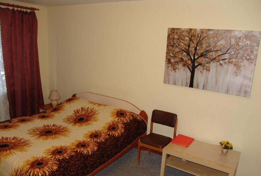 エカテリンブルクにあるApartment on Krasny Pereulok 8のベッドルーム1室(ベッド1台、テーブル、椅子付)