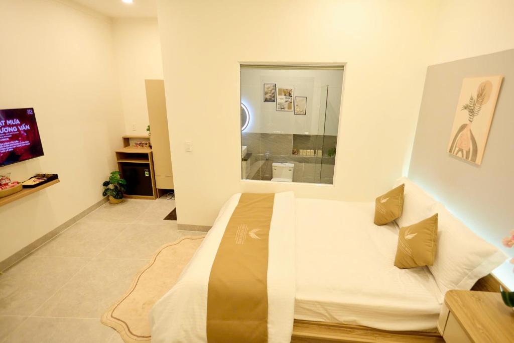 a bedroom with a bed and a television in it at Maison Boutique Hotel - Bình An in Phước Lộc Xã