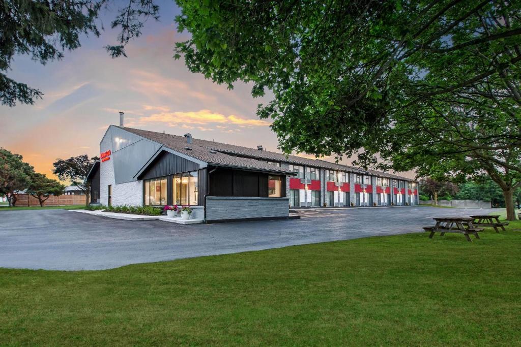 a building with a picnic table in a park at Ramada by Wyndham Kingston in Kingston