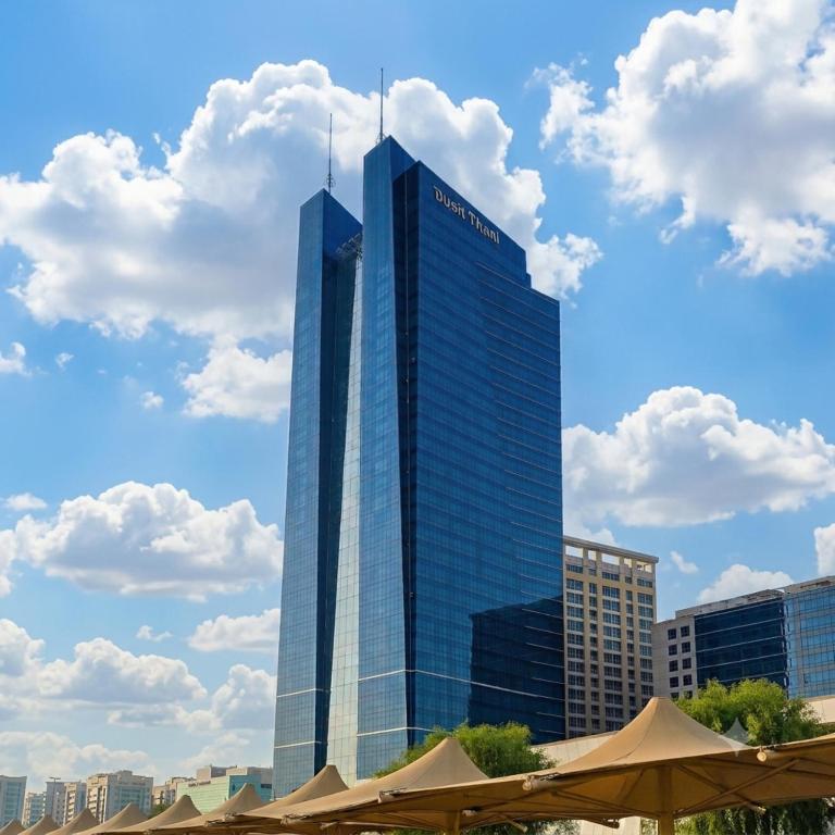 a tall glass building with two towers on top of it at Dusit Thani Abu Dhabi in Abu Dhabi