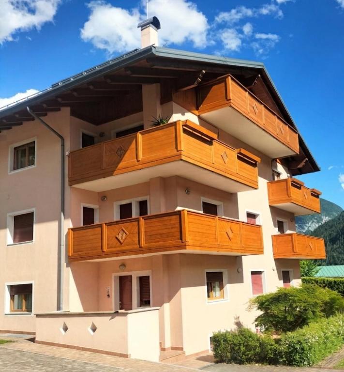 a building with wooden balconies on the side of it at Appartamento Daniela Dolomiti. in Auronzo di Cadore