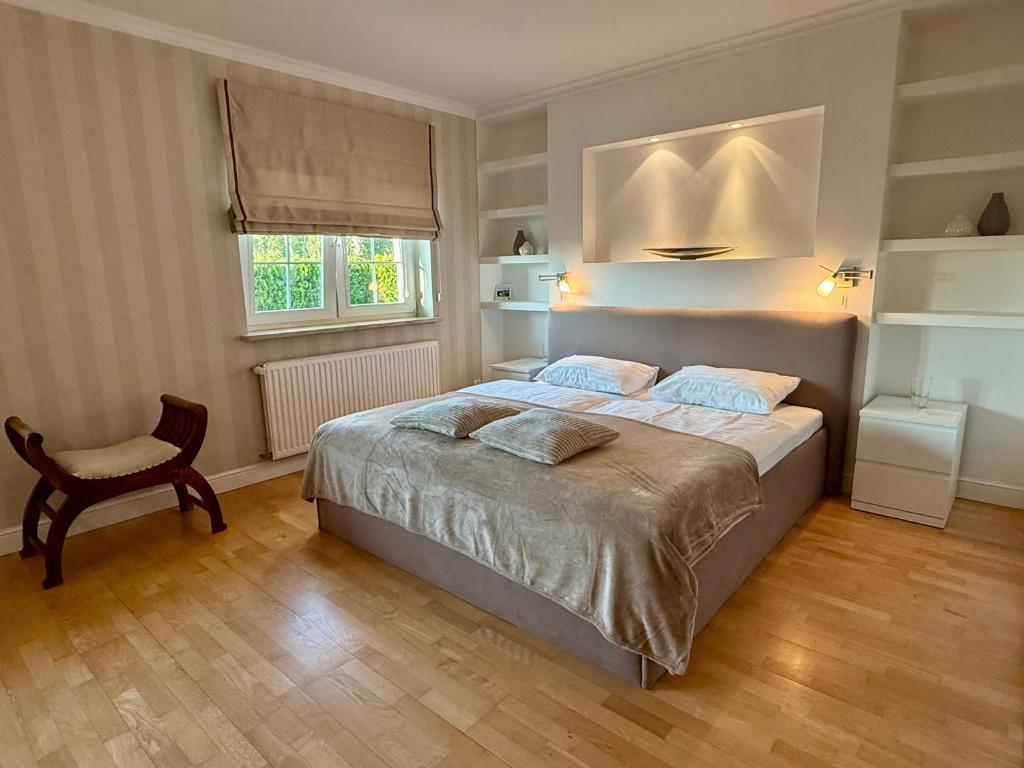 a bedroom with a bed and a chair and a window at Baltic Garden Villa in Gdynia