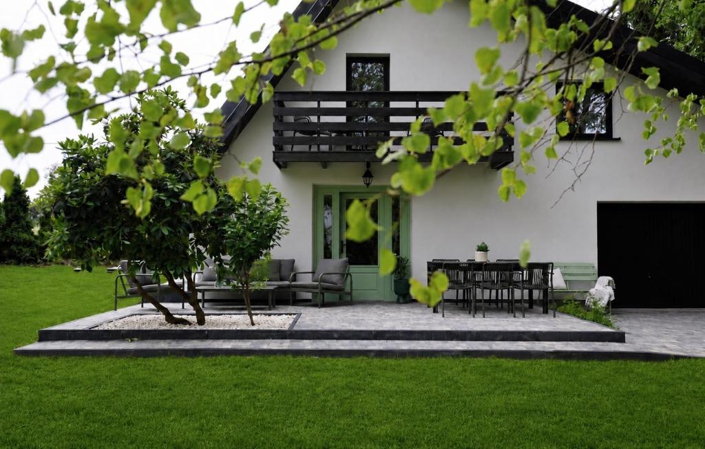 a house with a table and chairs in a yard at Leśne Chwile in Osiek