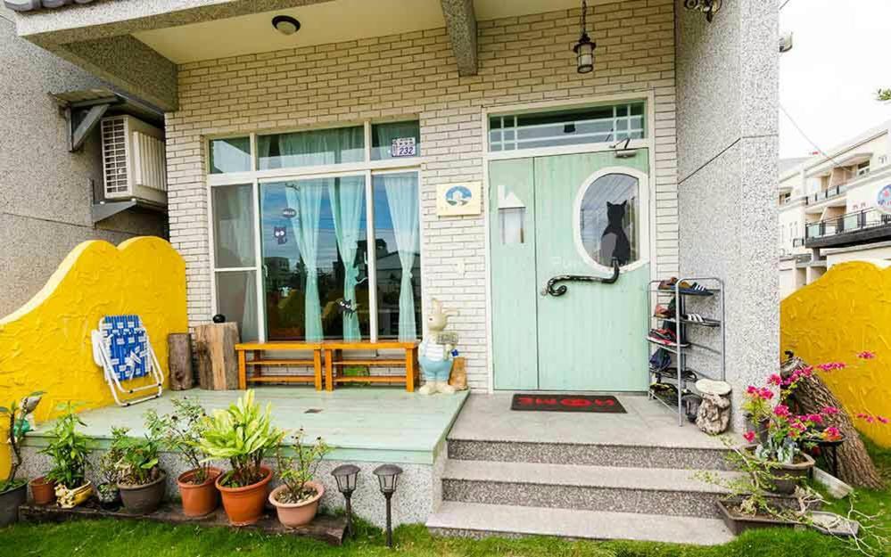 a house with a blue door and a bench at Slowly B&amp;B in Taitung City