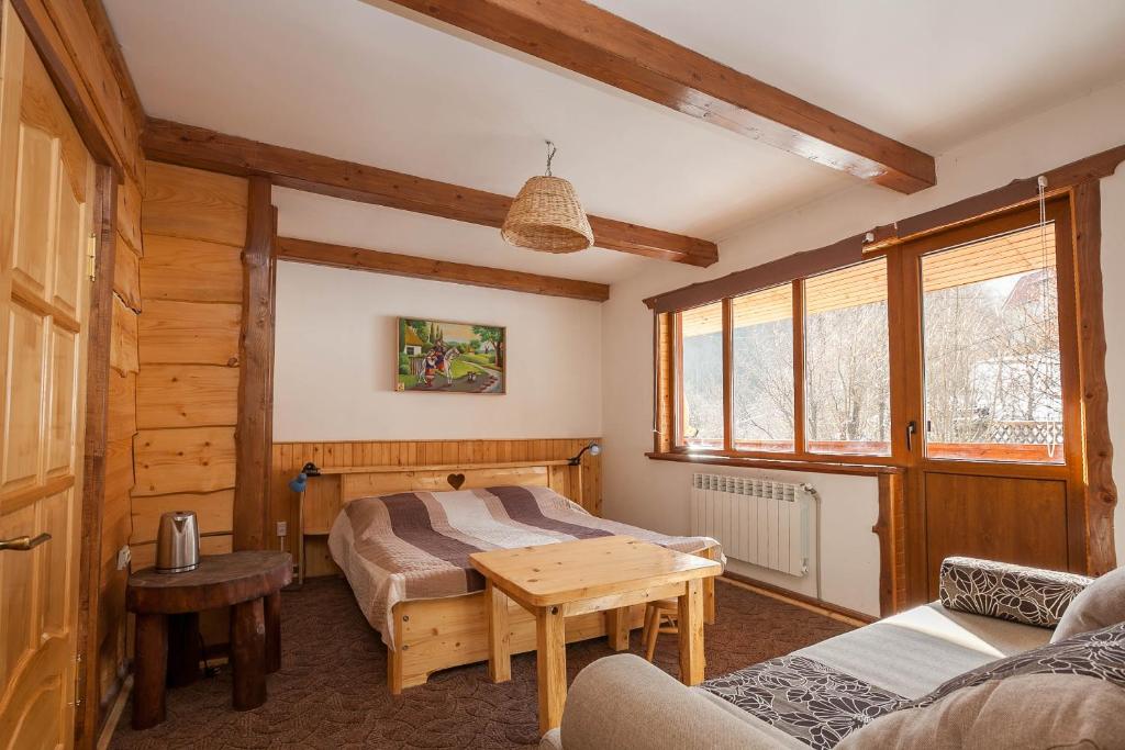 ein Schlafzimmer mit einem Bett und einem Tisch in einem Zimmer in der Unterkunft Vatra Hotel in Jaremtsche