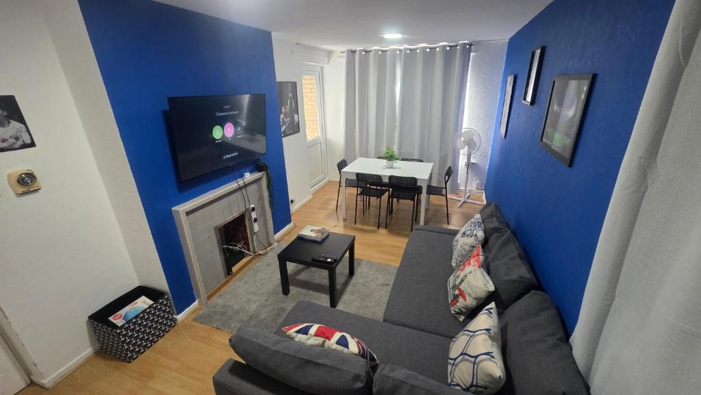 a living room with a couch and a blue wall at Totteham stadium in London