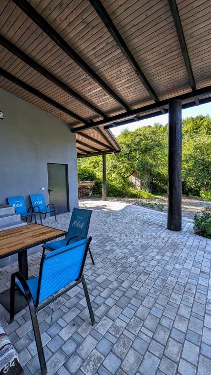 a patio with a wooden pergola and a wooden table and chairs at Хата над гуком in Kosiv