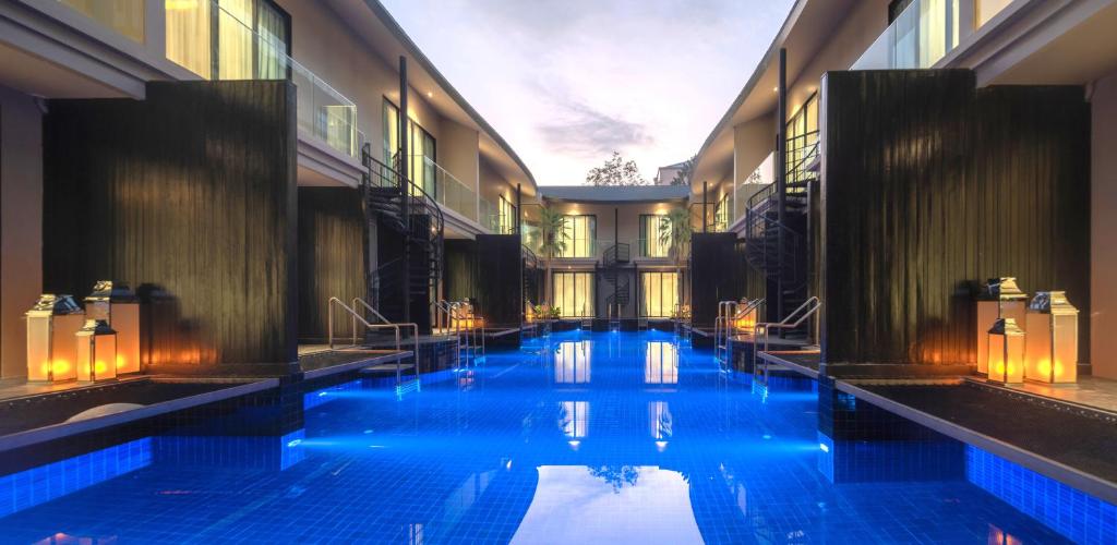 ein Schwimmbad mit blauen Lichtern in einem Gebäude in der Unterkunft Luminous Resort & Spa by Areca in Phuket