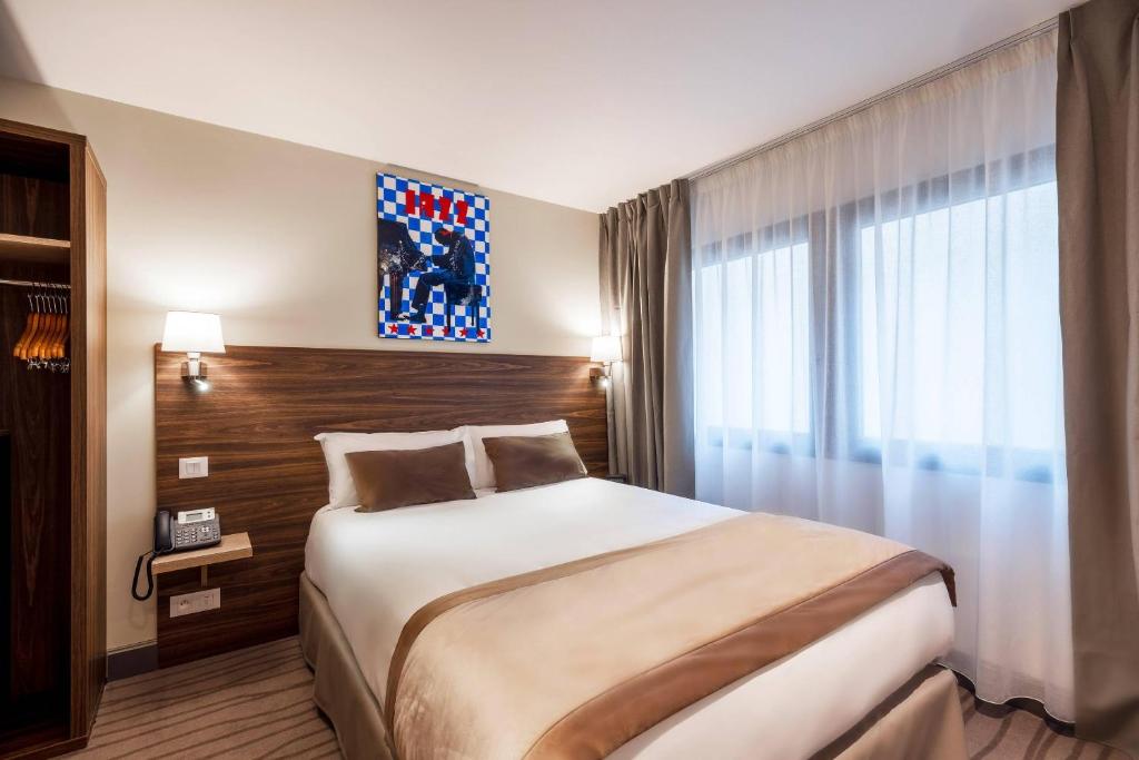 a hotel room with a bed and a window at Quality Hotel Toulouse Centre in Toulouse