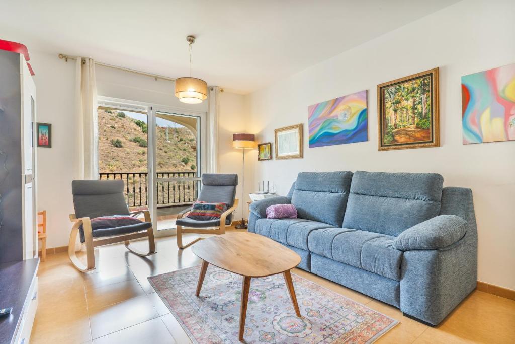 a living room with a blue couch and chairs at Apartment Mountain View Torrox town in Torrox