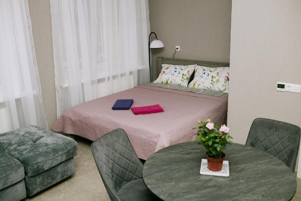 a room with a bed with a table and a couch at Marsas 2 in Zarasai