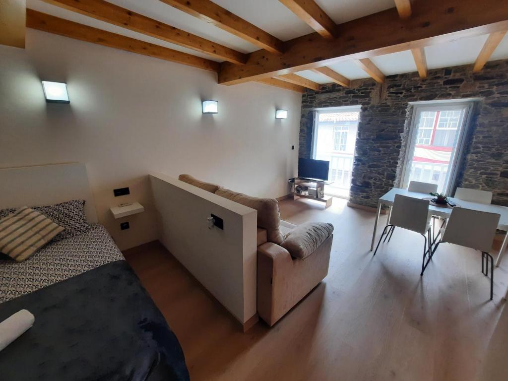 a living room with a bed and a table and chairs at O Recuncho de Mugardos in Mugardos